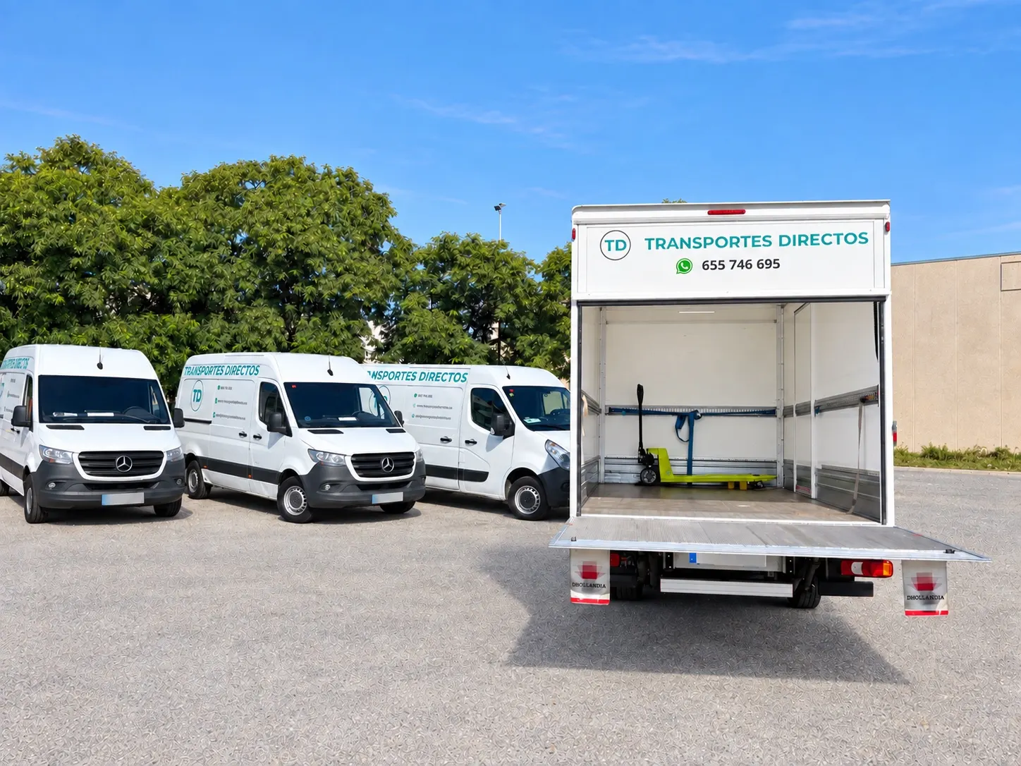 Camión carrozado con la caja abierta, la plataforma elevadora bajada y una transpaleta dentro