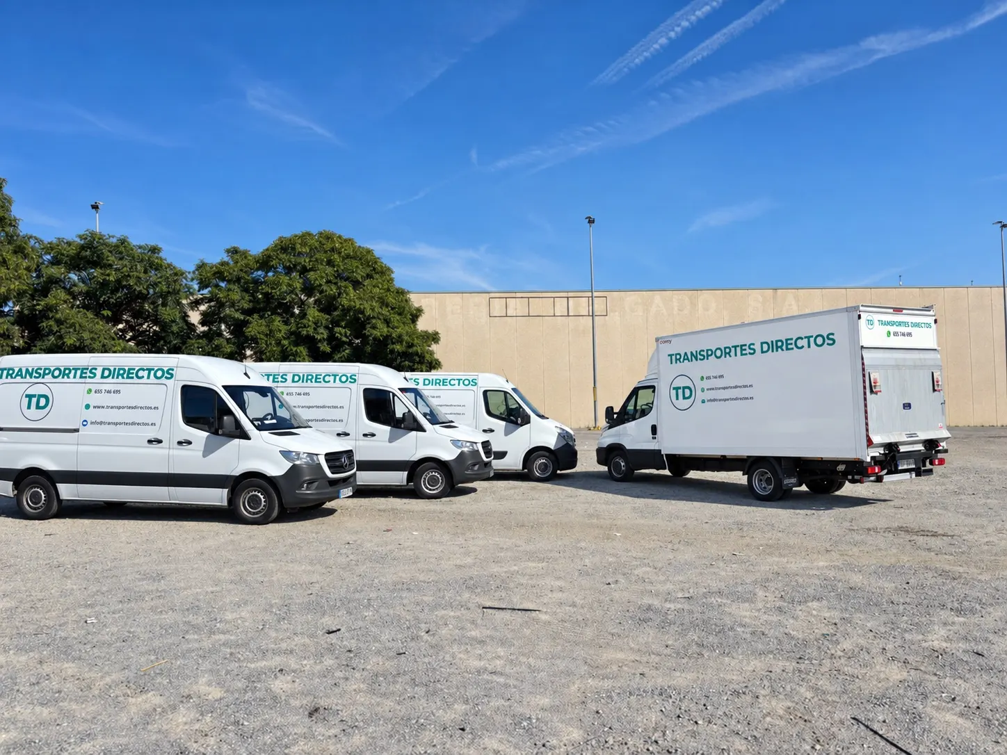 Furgonetas y camión carrozado propios de Transportes Directos aparcados